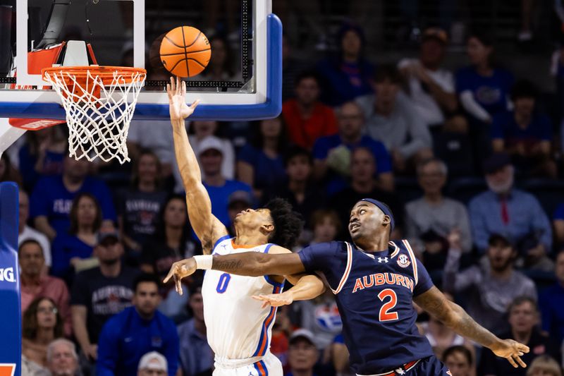 Feb 10, 2024; Gainesville, Florida, USA; Florida Gators guard Zyon Pullin (0) makes a layup over Auburn Tigers forward Jaylin Williams (2) during the first half at Exactech Arena at the Stephen C. O'Connell Center. Mandatory Credit: Matt Pendleton-USA TODAY Sports