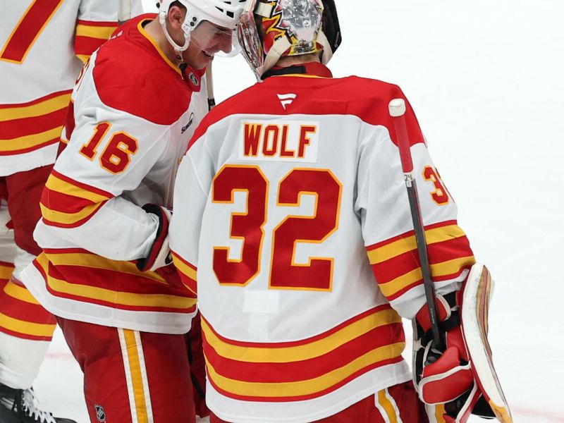Dec 13, 2025; Los Angeles, California, USA;  Calgary Flames center Morgan Frost (16) celebrates with goaltender Dustin Wolf (32) after defeating the Los Angeles Kings in overtime at Crypto.com Arena. Mandatory Credit: Kiyoshi Mio-Imagn Images