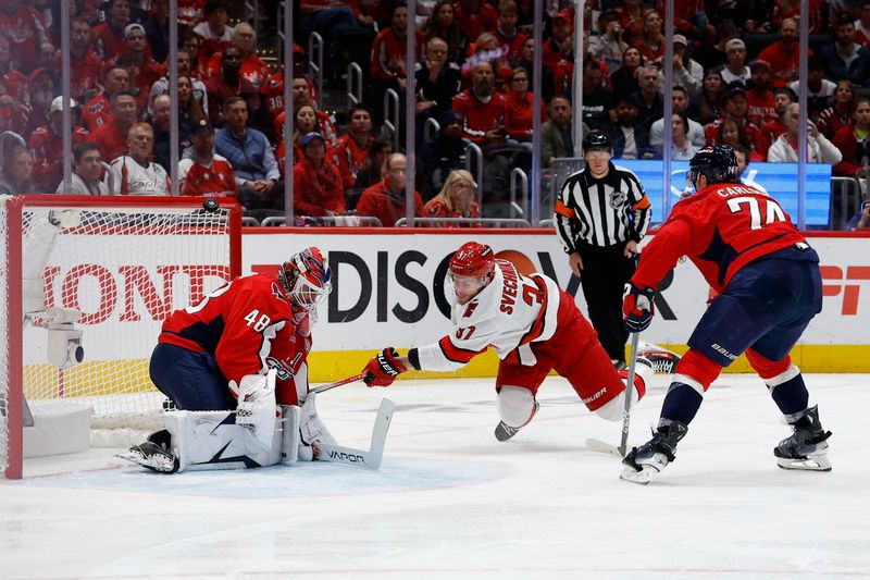 May 8, 2025; Washington, District of Columbia, USA; Washington Capitals goaltender Logan Thompson (48) makes a save on Carolina Hurricanes right wing Andrei Svechnikov (37) as Capitals defenseman John Carlson (74) defends in the second period in game two of the second round of the 2025 Stanley Cup Playoffs at Capital One Arena. Mandatory Credit: Geoff Burke-Imagn Images