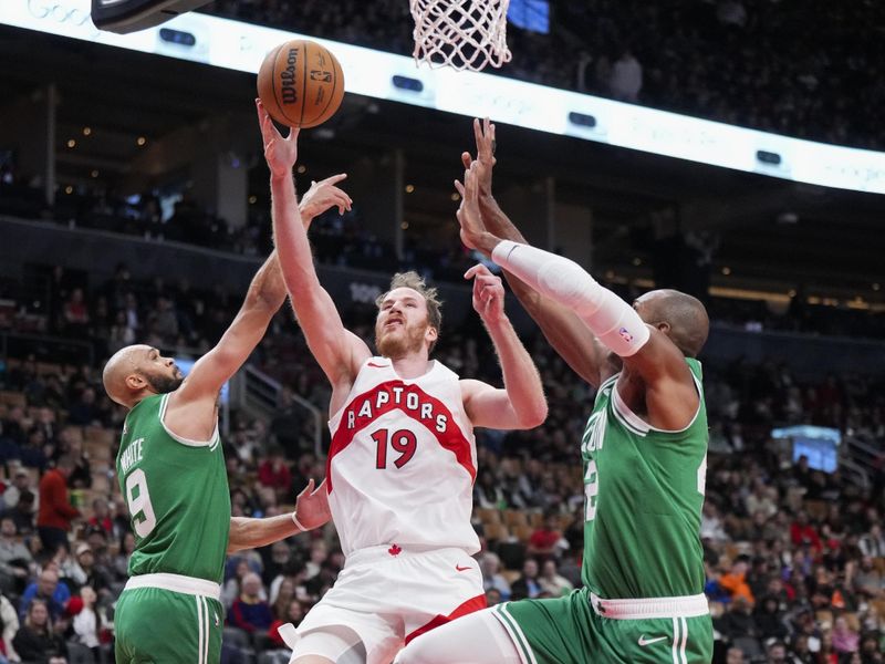 TORONTO, ON - OCTOBER 15: Jakob Poeltl #19 of the Toronto Raptors goes to the basket against Derrick White #9 and Al Horford #42 of the Boston Celtics during the second half of their preseason basketball game at the Scotiabank Arena on October 15, 2024 in Toronto, Ontario, Canada. NOTE TO USER: User expressly acknowledges and agrees that, by downloading and/or using this Photograph, user is consenting to the terms and conditions of the Getty Images License Agreement. (Photo by Mark Blinch/Getty Images)