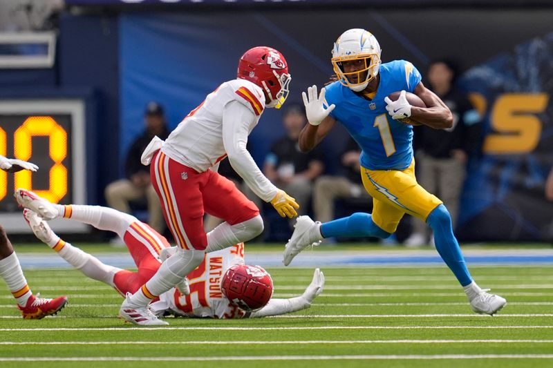 Los Angeles Chargers wide receiver Quentin Johnston (1) runs with the ball as Kansas City Chiefs wide receiver JuJu Smith-Schuster and cornerback Jaylen Watson, bottom, defend during the first half of an NFL football game Sunday, Sept. 29, 2024, in Inglewood, Calif. (AP Photo/Marcio Jose Sanchez)