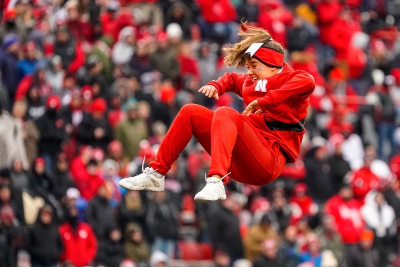 Oct 28, 2023; Lincoln, Nebraska, USA; A Nebraska Cornhuskers cheerleader is tossed into the air during a break in the third quarter against the Purdue Boilermakers at Memorial Stadium. Mandatory Credit: Dylan Widger-USA TODAY Sports