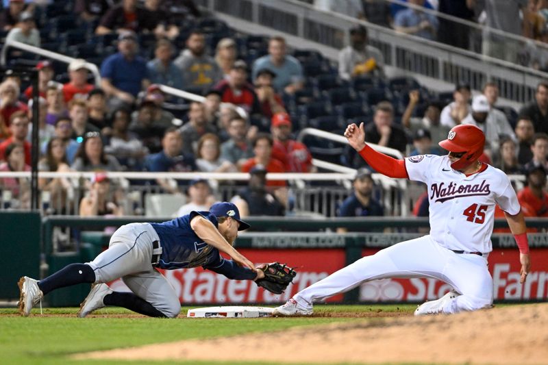 Apr 4, 2023; Washington, District of Columbia, USA; Washington Nationals designated hitter Joey Meneses (45) beats the tag attempt by Tampa Bay Rays third baseman Taylor Walls (6) during the fourth inning at third base at Nationals Park. Mandatory Credit: Brad Mills-USA TODAY Sports