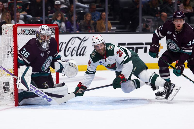 Mar 19, 2024; Anaheim, California, USA; Minnesota Wild right wing Ryan Hartman (38) trips over the skate of Anaheim Ducks defenseman Pavel Mintyukov (34) during the first period of a game at Honda Center. Mandatory Credit: Jessica Alcheh-USA TODAY Sports