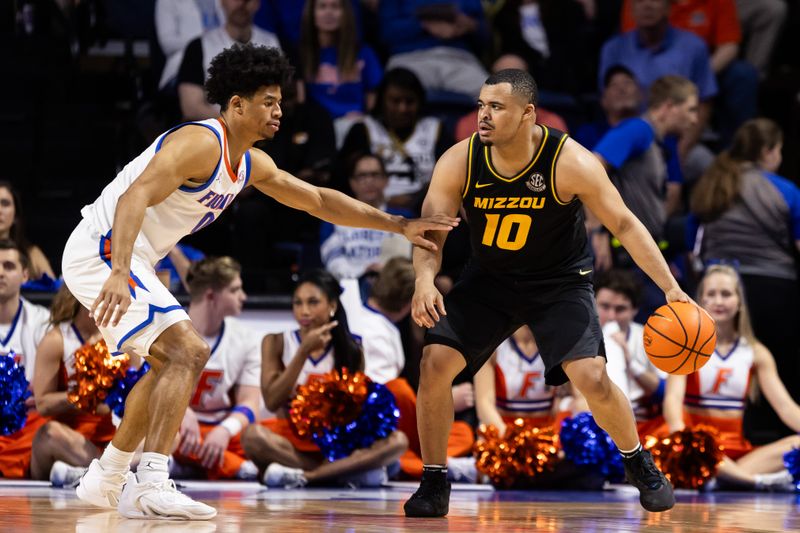 Feb 28, 2024; Gainesville, Florida, USA; Missouri Tigers guard Nick Honor (10) dribbles the ball at Florida Gators guard Zyon Pullin (0) during the second half at Exactech Arena at the Stephen C. O'Connell Center. Mandatory Credit: Matt Pendleton-USA TODAY Sports