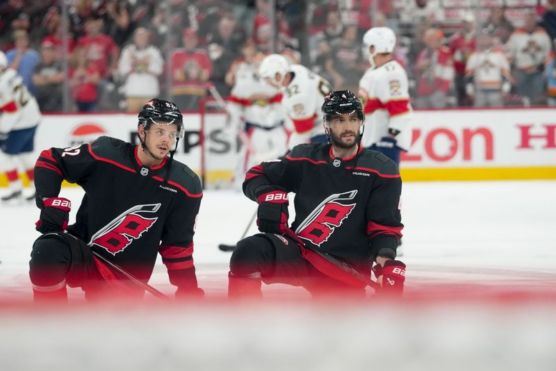 May 20, 2025; Raleigh, North Carolina, USA; Carolina Hurricanes forward Jesperi Kotkaniemi (82) and defenseman Shayne Gostibehere (4) warm up priorto the during the first period against the Florida Panthers in game one of the Eastern Conference Final of the 2025 Stanley Cup Playoffs at Lenovo Center. Mandatory Credit: James Guillory-Imagn Images