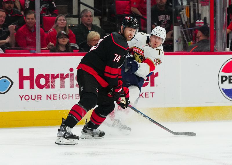 Mar 14, 2024; Raleigh, North Carolina, USA; Carolina Hurricanes defenseman Jaccob Slavin (74) blocks the shot attempt by Florida Panthers defenseman Niko Mikkola (77) during the second period at PNC Arena. Mandatory Credit: James Guillory-USA TODAY Sports