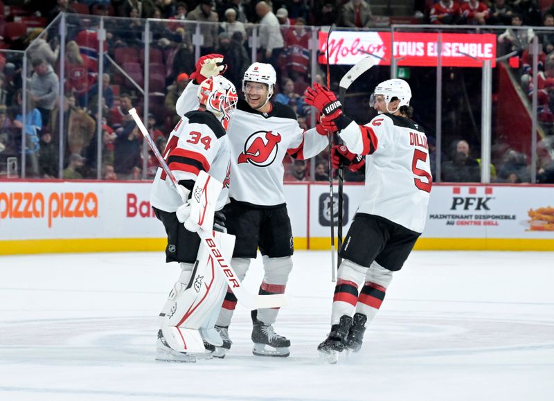 Jan 25, 2025; Montreal, Quebec, CAN; New Jersey Devils goalie Jake Allen (34) celebrates the win against the Montreal Canadiens with teammates defenseman Johnathan Kovacevic (8) and defenseman Brenden Dillon (5) at the Bell Centre. Mandatory Credit: Eric Bolte-Imagn Images