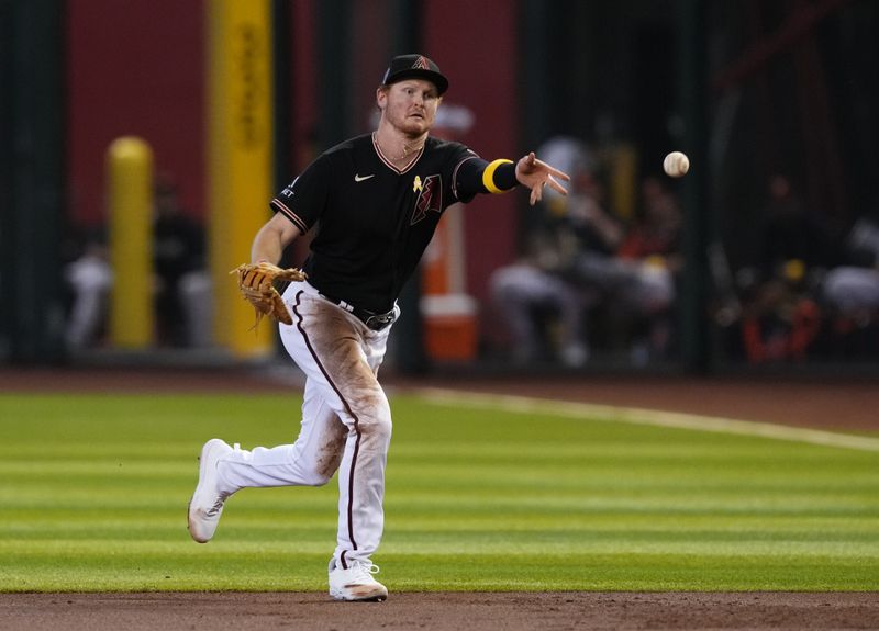 Sep 3, 2023; Phoenix, Arizona, USA; Arizona Diamondbacks first baseman Pavin Smith (26) flips the ball during the third inning against the Baltimore Orioles at Chase Field. Mandatory Credit: Joe Camporeale-USA TODAY Sports