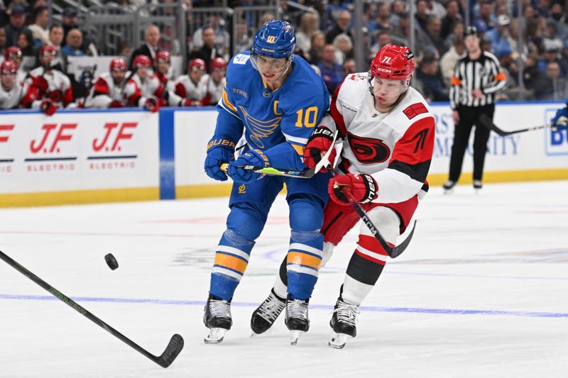 Jan 13, 2026; St. Louis, Missouri, USA; St. Louis Blues center Brayden Schenn (10) and Carolina Hurricanes left wing Taylor Hall (71) look for control of the puck in the second period at Enterprise Center. Mandatory Credit: Joe Puetz-Imagn Images