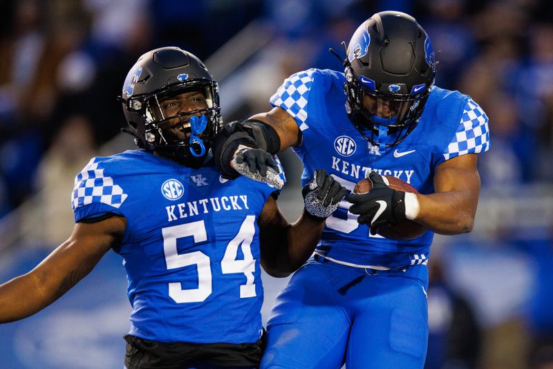 Nov 26, 2022; Lexington, Kentucky, USA; Kentucky Wildcats linebacker Trevin Wallace (32) celebrates with linebacker D'Eryk Jackson (54) after intercepting a Louisville Cardinals pass during the third quarter at Kroger Field. Mandatory Credit: Jordan Prather-USA TODAY Sports