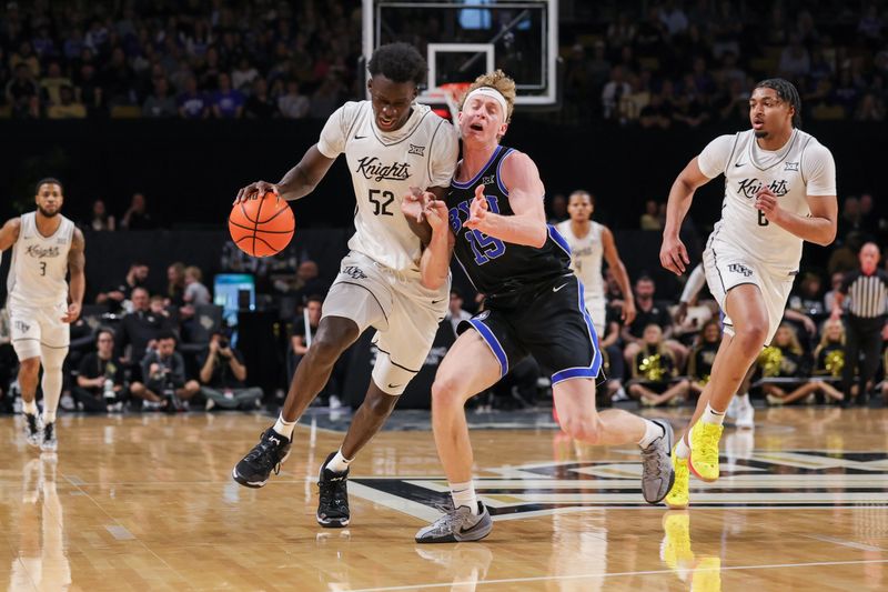 Feb 1, 2025; Orlando, Florida, USA; UCF Knights center Moustapha Thiam (52) drives around Brigham Young Cougars forward Richie Saunders (15) during the first half at Addition Financial Arena. Mandatory Credit: Mike Watters-Imagn Images