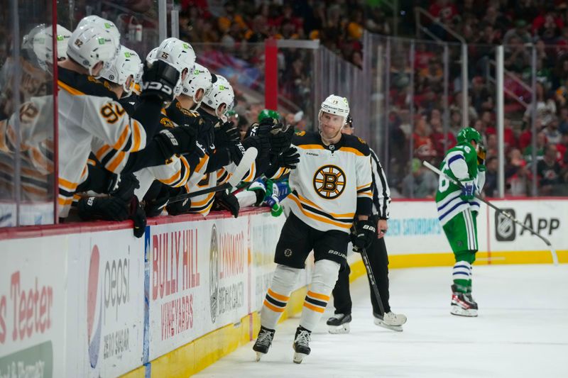 Mar 26, 2023; Raleigh, North Carolina, USA;  Boston Bruins center Charlie Coyle (13) scores a shoot out goal against the Carolina Hurricanes (31) at PNC Arena. Mandatory Credit: James Guillory-USA TODAY Sports