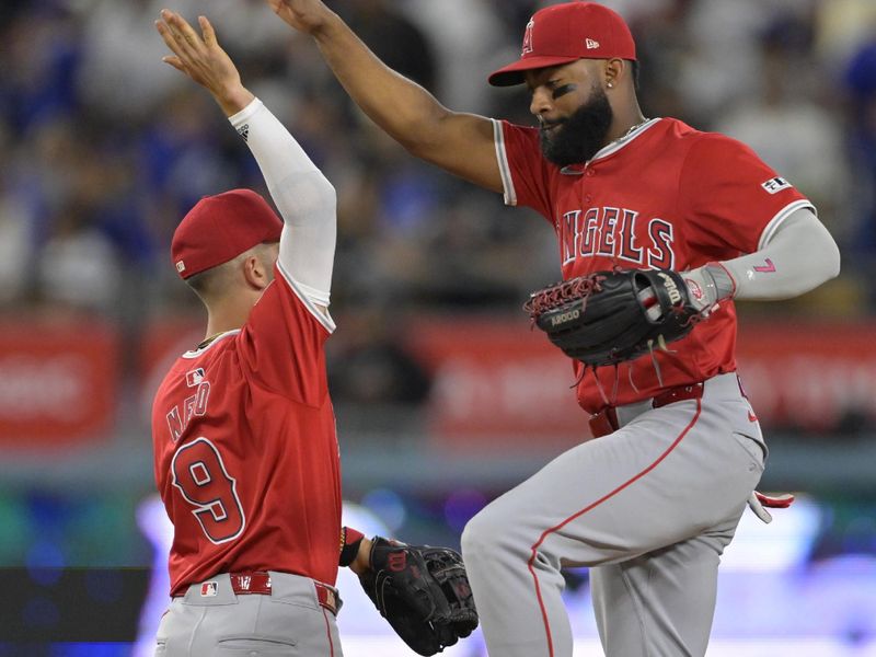 Jun 21, 2024; Los Angeles, California, USA;  Los Angeles Angels shortstop Zach Neto (9) and right fielder Jo Adell (7) celebrate after defeating the Los Angeles Dodgers in the 10th inning at Dodger Stadium. Mandatory Credit: Jayne Kamin-Oncea-USA TODAY Sports