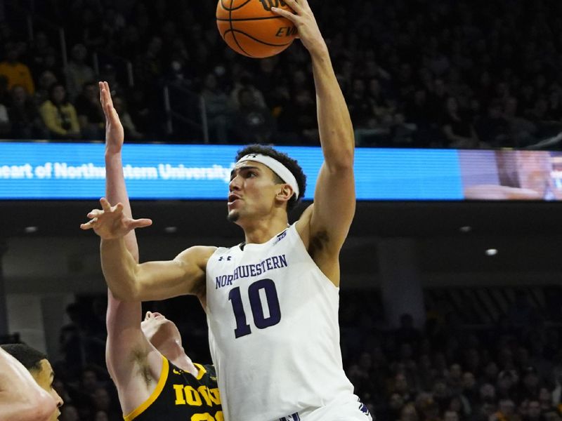 Feb 19, 2023; Evanston, Illinois, USA; \c10 shoots over Iowa Hawkeyes forward Patrick McCaffery (22) during the second half at Welsh-Ryan Arena. Mandatory Credit: David Banks-USA TODAY Sports