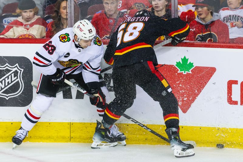 Jan 27, 2024; Calgary, Alberta, CAN; Chicago Blackhawks center Philipp Kurashev (23) and Calgary Flames defenseman Oliver Kylington (58) battles for the puck during the first period at Scotiabank Saddledome. Mandatory Credit: Sergei Belski-USA TODAY Sports