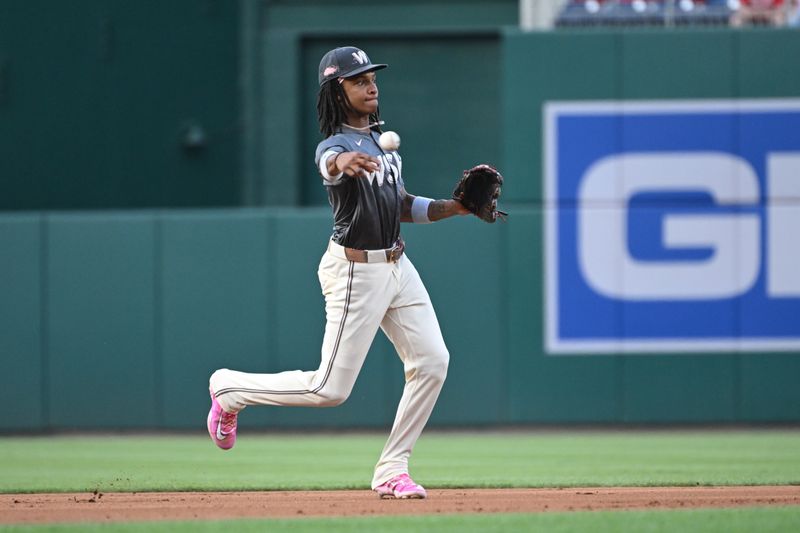 Aug 2, 2024; Washington, District of Columbia, USA; Washington Nationals shortstop CJ Abrams (5) attempts a throw to first base against the Milwaukee Brewers during the first inning at Nationals Park. Mandatory Credit: Rafael Suanes-USA TODAY Sports