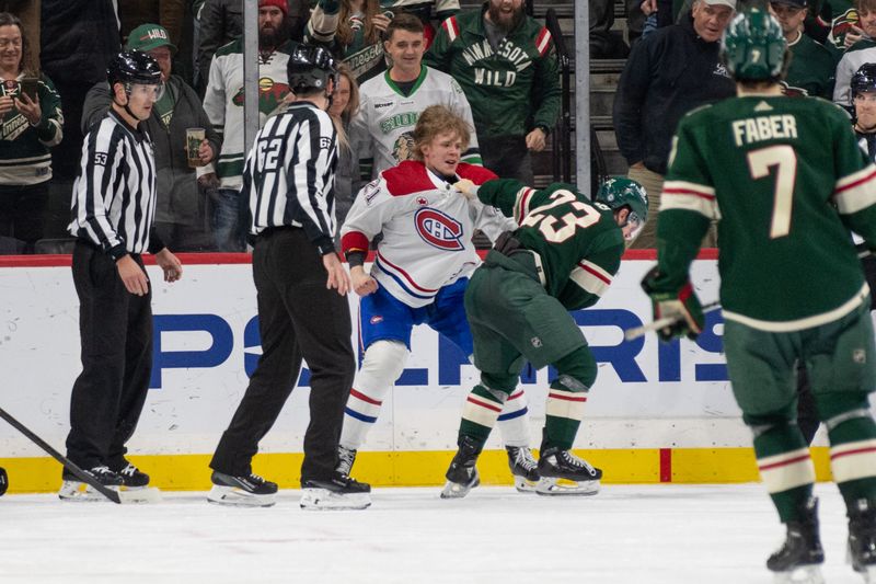 Dec 21, 2023; Saint Paul, Minnesota, USA; Minnesota Wild center Marco Rossi (23) and Montreal Canadiens defenseman Kaiden Guhle (21) fight in the second period at Xcel Energy Center. Mandatory Credit: Matt Blewett-USA TODAY Sports