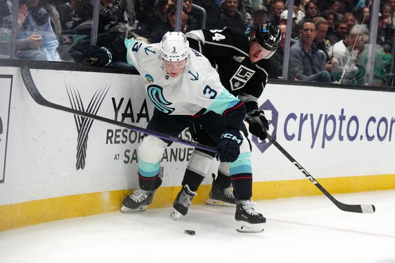 Dec 20, 2023; Los Angeles, California, USA; Seattle Kraken defenseman Will Borgen (3) and LA Kings right wing Arthur Kaliyev (34) battle for the puck in the second period at Crypto.com Arena. Mandatory Credit: Kirby Lee-USA TODAY Sports