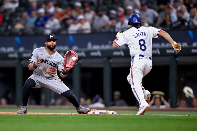 Aug 15, 2024; Arlington, Texas, USA; Minnesota Twins first baseman Carlos Santana (30) fields a throw to first base to put out Texas Rangers shortstop Josh Smith (8) for the final out during the ninth inning at Globe Life Field. Mandatory Credit: Jerome Miron-USA TODAY Sports