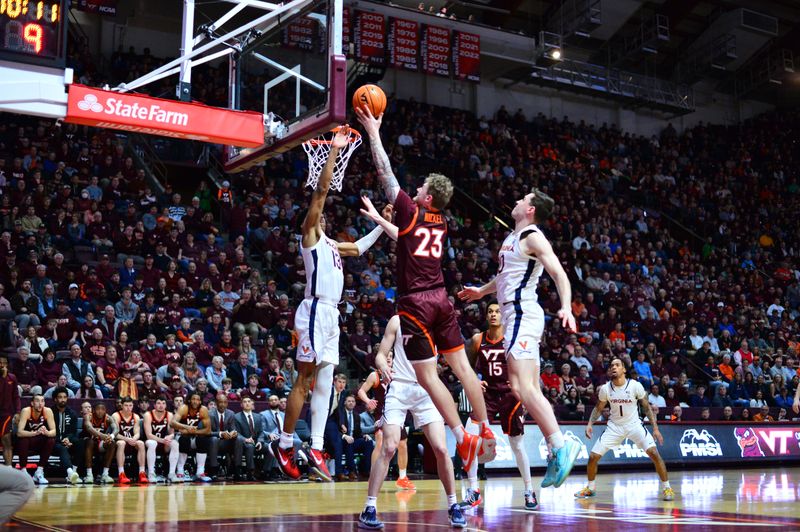 Feb 19, 2024; Blacksburg, Virginia, USA; Virginia Tech Hokies guard Tyler Nickel (23) goes in for a layup as Virginia Cavaliers guard Ryan Dunn (13) defends during the second half at Cassell Coliseum. Mandatory Credit: Brian Bishop-USA TODAY Sports