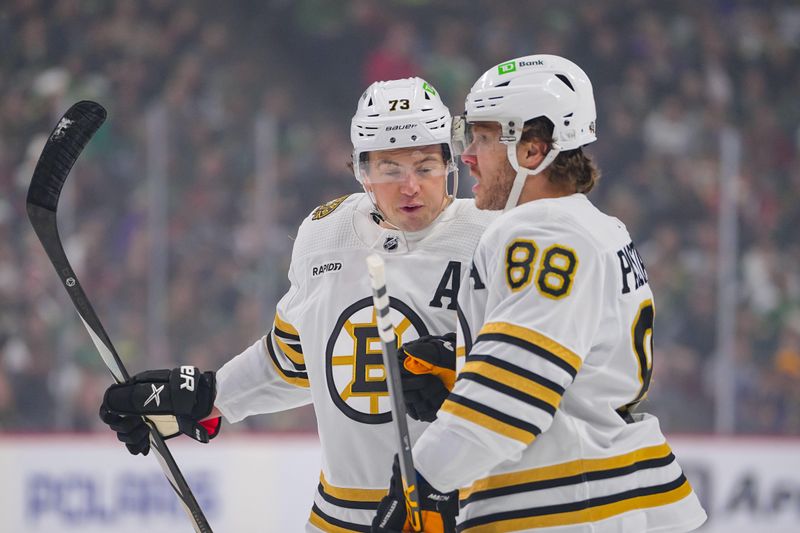 Dec 23, 2023; Saint Paul, Minnesota, USA; Boston Bruins right wing David Pastrnak (88) celebrates his goal with defenseman Charlie McAvoy (73) against the Minnesota Wild in the first period at Xcel Energy Center. Mandatory Credit: Brad Rempel-USA TODAY Sports