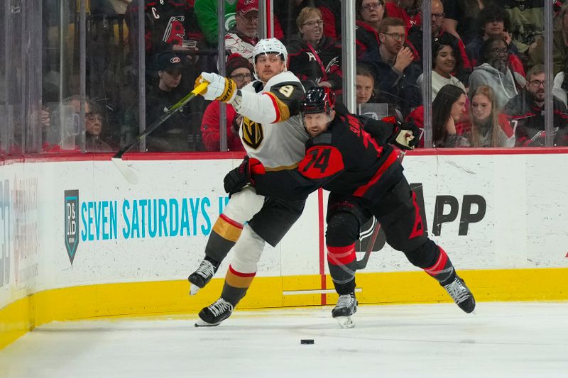 Mar 11, 2023; Raleigh, North Carolina, USA;  Vegas Golden Knights center Jack Eichel (9) and Carolina Hurricanes defenseman Jaccob Slavin (74) battle over the puck during the third period at PNC Arena. Mandatory Credit: James Guillory-USA TODAY Sports