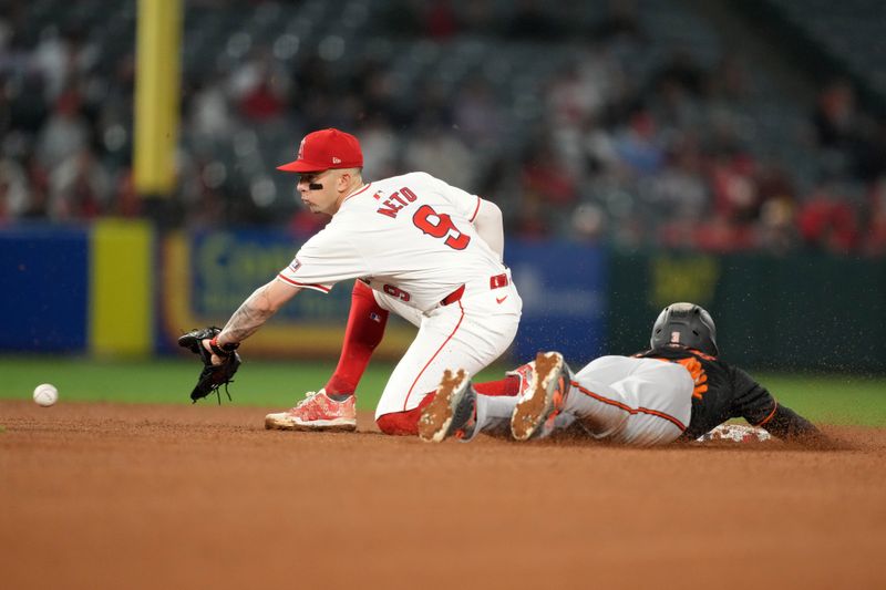 Apr 22, 2024; Anaheim, California, USA; Baltimore Orioles center fielder Cedric Mullins (31) slides into second base beneath the tag of Los Angeles Angels shortstop Zach Neto (9) for a stolen base in the ninth inning at Angel Stadium. Mandatory Credit: Kirby Lee-USA TODAY Sports