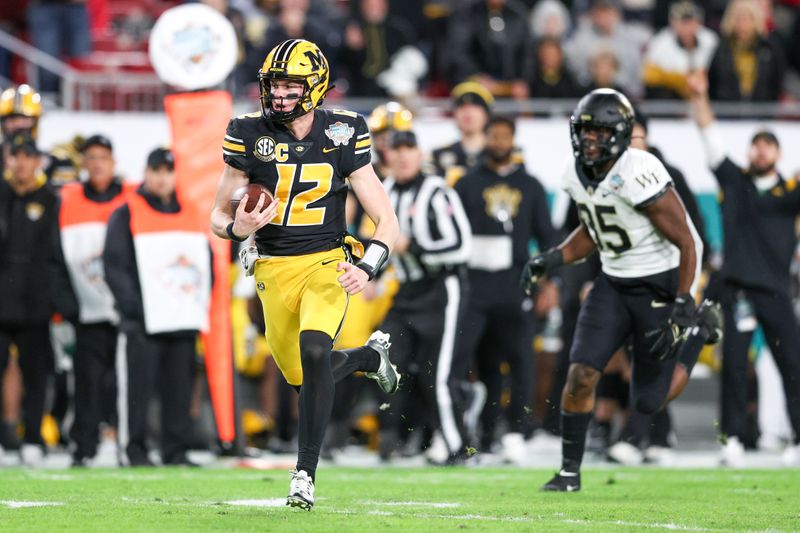 Dec 23, 2022; Tampa, Florida, USA; Missouri Tigers quarterback Brady Cook (12) runs with the ball against the Wake Forest Demon Deacons in the second quarter in the 2022 Gasparilla Bowl at Raymond James Stadium. Mandatory Credit: Nathan Ray Seebeck-USA TODAY Sports