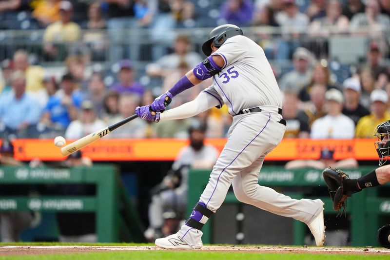 May 3, 2024; Pittsburgh, Pennsylvania, USA; Colorado Rockies catcher Elias Diaz (35) hits a single against the Pittsburgh Pirates during the first inning at PNC Park. Mandatory Credit: Gregory Fisher-USA TODAY Sports