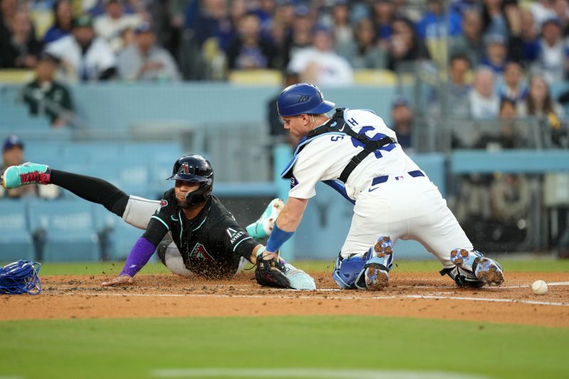 May 21, 2024; Los Angeles, California, USA; Arizona Diamondbacks left fielder Lourdes Gurriel Jr. (12) slides into second base to beat a throw to Los Angeles Dodgers catcher Will Smith (16) to score in the second inning at Dodger Stadium. Mandatory Credit: Kirby Lee-USA TODAY Sports