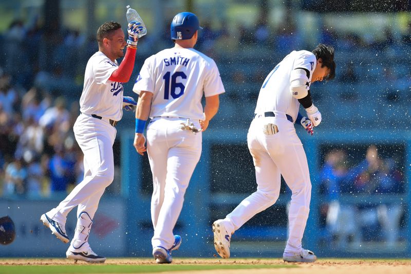 May 19, 2024; Los Angeles, California, USA; Los Angeles Dodgers shortstop Miguel Rojas (11) and catcher Will Smith (16) celebrate after designated hitter Shohei Ohtani (17) hits a walk off RBI single against the Cincinnati Reds at Dodger Stadium. Mandatory Credit: Gary A. Vasquez-USA TODAY Sports