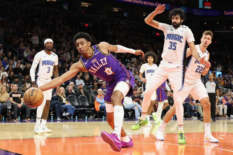 PHOENIX, ARIZONA - NOVEMBER 18: Ryan Dunn #0 of the Phoenix Suns attempts to save the ball ahead of Goga Bitadze #35 of the Orlando Magicduring the second half of the NBA game at Footprint Center on November 18, 2024 in Phoenix, Arizona.  NOTE TO USER: User expressly acknowledges and agrees that, by downloading and/or using this photograph, user is consenting to the terms and conditions of the Getty Images License Agreement. (Photo by Christian Petersen/Getty Images)