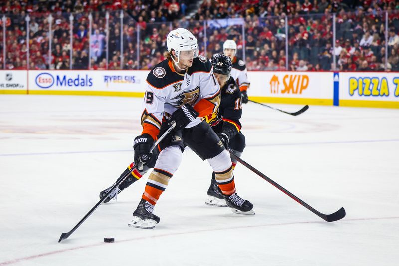 Apr 2, 2024; Calgary, Alberta, CAN; Anaheim Ducks right wing Troy Terry (19) controls the puck against Calgary Flames left wing A.J. Greer (18) during the second period at Scotiabank Saddledome. Mandatory Credit: Sergei Belski-USA TODAY Sports