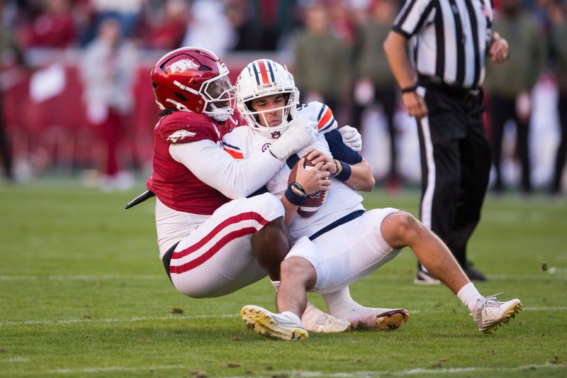 Nov 11, 2023; Fayetteville, Arkansas, USA;  Arkansas Razorbacks defensive lineman Trajan Jeffcoat (7) sacks Auburn Tigers quarterback Payton Thorne (1) during the second quarter at Donald W. Reynolds Razorback Stadium. Mandatory Credit: Brett Rojo-USA TODAY Sports