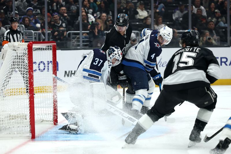 Nov 4, 2025; Los Angeles, California, USA;  Winnipeg Jets goaltender Connor Hellebuyck (37) defends the goal against Los Angeles Kings right wing Corey Perry (10) during the second period at Crypto.com Arena. Mandatory Credit: Kiyoshi Mio-Imagn Images