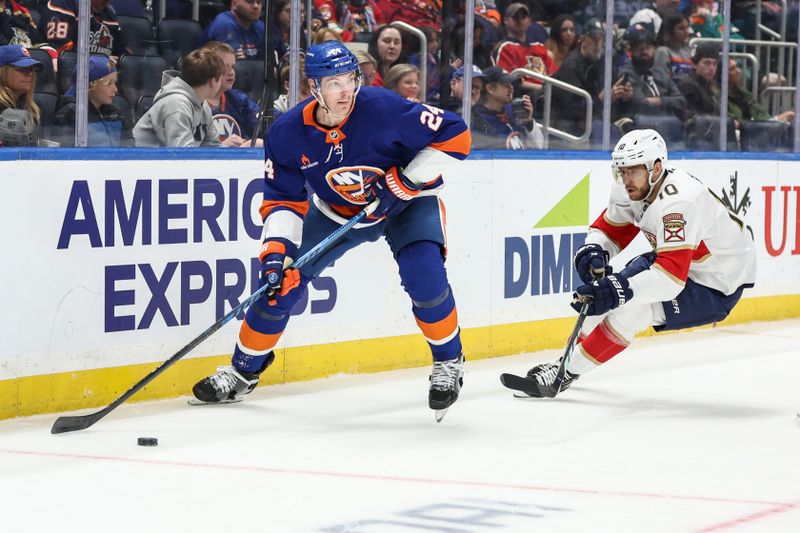 Mar 16, 2025; Elmont, New York, USA;  Florida Panthers left wing A.J. Greer (10) chases after New York Islanders defenseman Scott Mayfield (24) for control of the puck in the first period at UBS Arena. Mandatory Credit: Wendell Cruz-Imagn Images