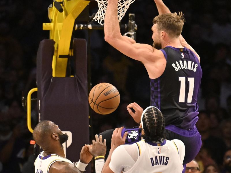 LOS ANGELES, CALIFORNIA - OCTOBER 26: Domantas Sabonis #11 of the Sacramento Kings got pas LeBron James #23 of the Los Angeles Lakers and Anthony Davis #3 for a dunk in the second half at Crypto.com Arena on October 26, 2024 in Los Angeles, California. NOTE TO USER: User expressly acknowledges and agrees that, by downloading and or using this photograph, User is consenting to the terms and conditions of the Getty Images License Agreement. (Photo by John McCoy/Getty Images)