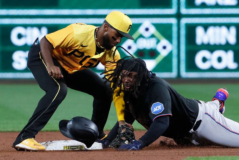 Sep 29, 2023; Pittsburgh, Pennsylvania, USA;  Miami Marlins first baseman Josh Bell (9) arrives at second base with a two RBI double as Pittsburgh Pirates shortstop Liover Peguero (60) applies a late tag during the eighth inning at PNC Park. Mandatory Credit: Charles LeClaire-USA TODAY Sports