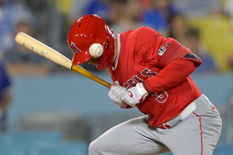 Jun 21, 2024; Los Angeles, California, USA;  Los Angeles Angels left fielder Taylor Ward (3) is hit by a pitch in the 10th inning against the Los Angeles Dodgers at Dodger Stadium. Mandatory Credit: Jayne Kamin-Oncea-USA TODAY Sports