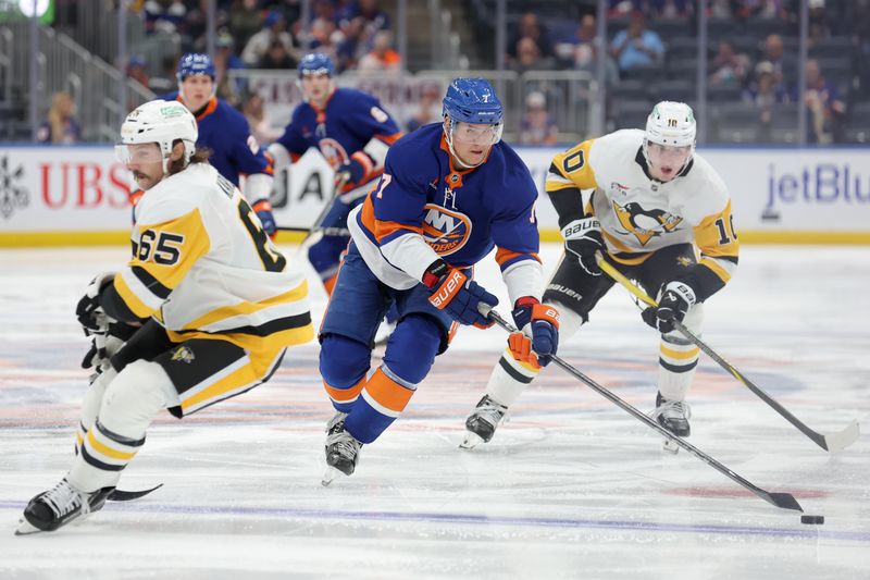 Nov 5, 2024; Elmont, New York, USA; New York Islanders right wing Maxim Tsyplakov (7) skates with the puck against Pittsburgh Penguins defenseman Erik Karlsson (65) and left wing Drew O'Connor (10) during the second period at UBS Arena. Mandatory Credit: Brad Penner-Imagn Images