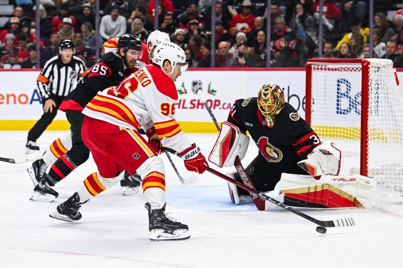 Nov 25, 2024; Ottawa, Ontario, CAN; Calgary Flames left wing Andrei Kuzmenko (96) plays the puck near Ottawa Senators goalie Anton Forsberg (31) during the second period at Canadian Tire Centre. Mandatory Credit: David Kirouac-Imagn Images