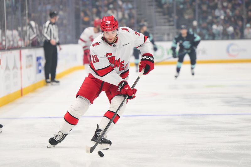 Oct 26, 2024; Seattle, Washington, USA; Carolina Hurricanes defenseman Sean Walker (26) advances the puck against the Seattle Kraken during the first period at Climate Pledge Arena. Mandatory Credit: Steven Bisig-Imagn Images