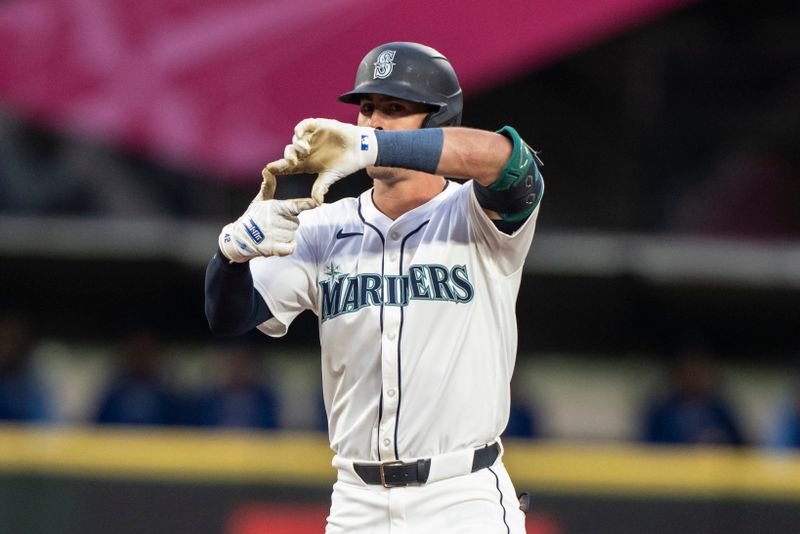 May 13, 2024; Seattle, Washington, USA; Seattle Mariners shortstop Dylan Moore (25) celebrates at second base after hitting a double during the second inning against the Kansas City Royals at T-Mobile Park. Mandatory Credit: Stephen Brashear-USA TODAY Sports