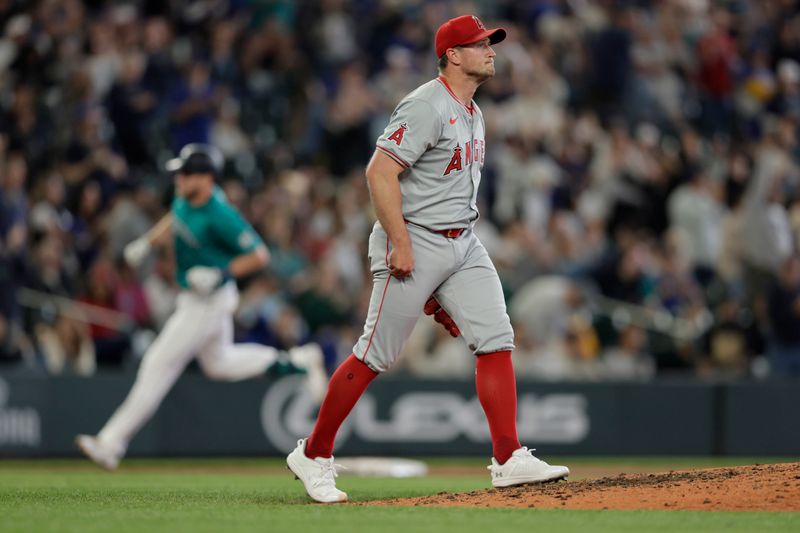 Jun 1, 2024; Seattle, Washington, USA;  Los Angeles Angels pitcher Carson Fulmer (41) reacts to a hit by Seattle Mariners left fielderer Luke Raley, rounding the bases behind, during the sixth inning at T-Mobile Park. Mandatory Credit: John Froschauer-USA TODAY Sports