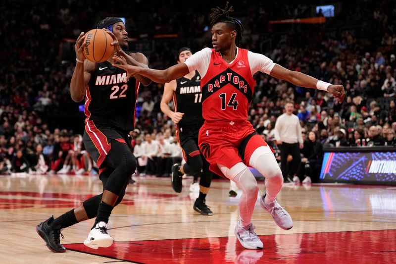 TORONTO, ON - DECEMBER 1: Jimmy Butler #22 of the Miami Heat drives to the basket against Ja'Kobe Walter #14 of the Toronto Raptors at Scotiabank Arena on December 1, 2024 in Toronto, Ontario, Canada. NOTE TO USER: User expressly acknowledges and agrees that, by downloading and/or using this Photograph, user is consenting to the terms and conditions of the Getty Images License Agreement. (Photo by Andrew Lahodynskyj/Getty Images)