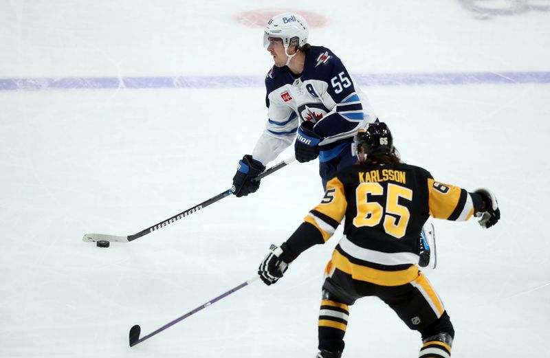 Nov 22, 2024; Pittsburgh, Pennsylvania, USA; Winnipeg Jets center Mark Scheifele (55) moves the puck against Pittsburgh Penguins defenseman Erik Karlsson (65) during the second period at PPG Paints Arena. Mandatory Credit: Charles LeClaire-Imagn Images