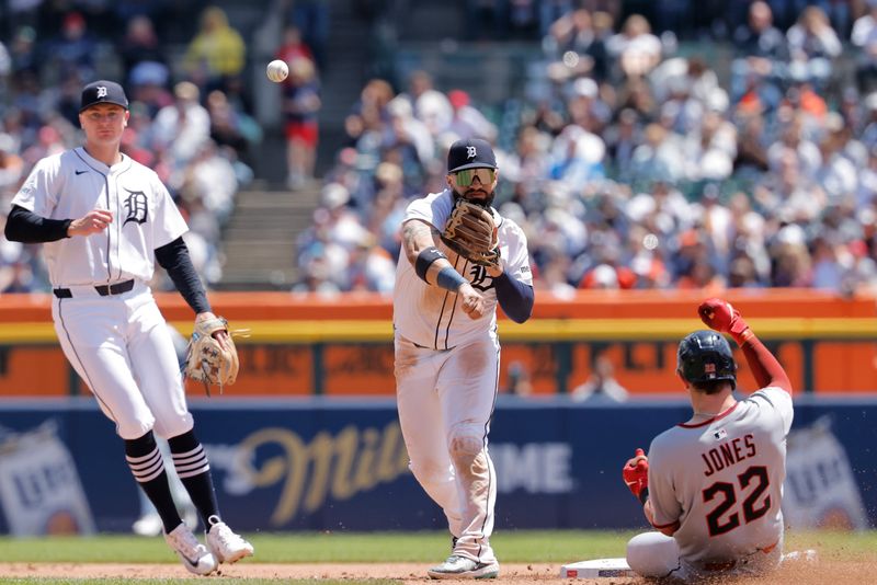 May 25, 2025; Detroit, Michigan, USA;  Detroit Tigers second base Gleyber Torres (25) makes a throw to first to complete a double play as Cleveland Guardians outfielder Nolan Jones (22) slides into second in the fifth inning at Comerica Park. Mandatory Credit: Rick Osentoski-Imagn Images
