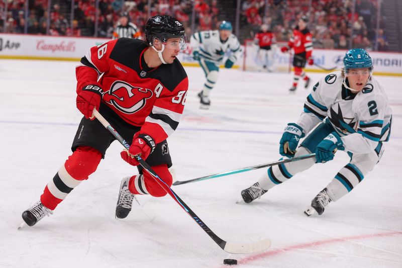 Oct 24, 2025; Newark, New Jersey, USA; New Jersey Devils center Jack Hughes (86) skates with the puck as San Jose Sharks center Will Smith (2) defends during the second period at Prudential Center. Mandatory Credit: Ed Mulholland-Imagn Images