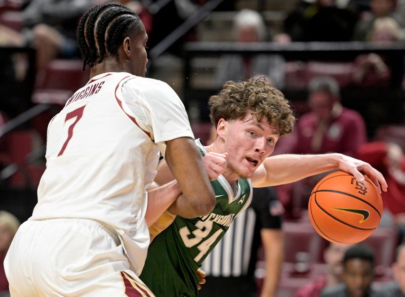 Dec 22, 2025; Tallahassee, Florida, USA; Jacksonville University Dolphins guard Evan Sterck (34) drives to the net versus Florida State Seminoles forward Chauncey Wiggins (7) during the first half at Donald L. Tucker Center. Mandatory Credit: Melina Myers-Imagn Images